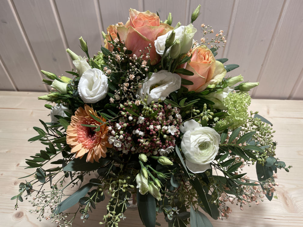 Ein Strauss mit rosa Rosen und grünem Kraut