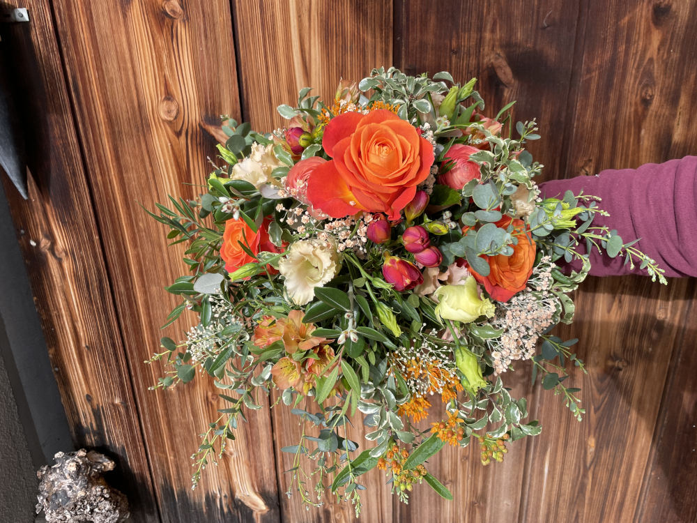 Ein Strauss mit rote Blumen auf dunkles Holz