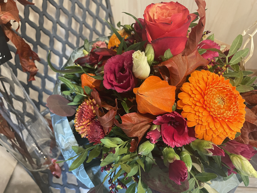 Ein Strauss mit eine grosser oranger Blume und einer rote Rose