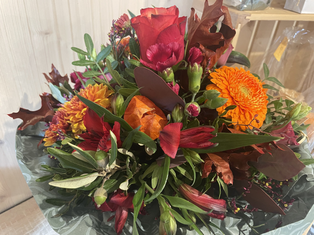 Einen Strauss mit einem Orangen Ton aber mit einer rote Rose