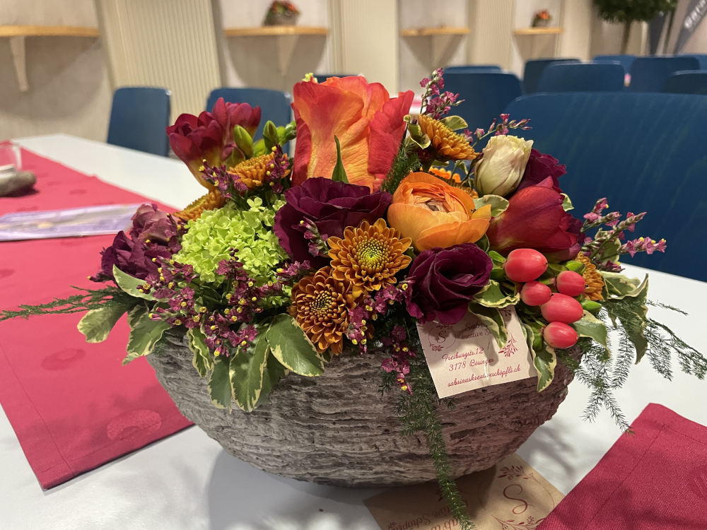 Tischdekoration mit einer Schale und verschiedene Blumen