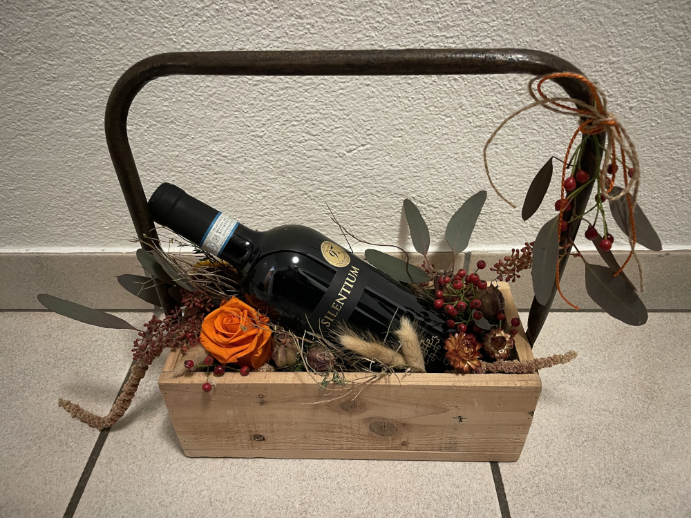 Eine Flasche Wein die im einem Blumenkörkem liegt