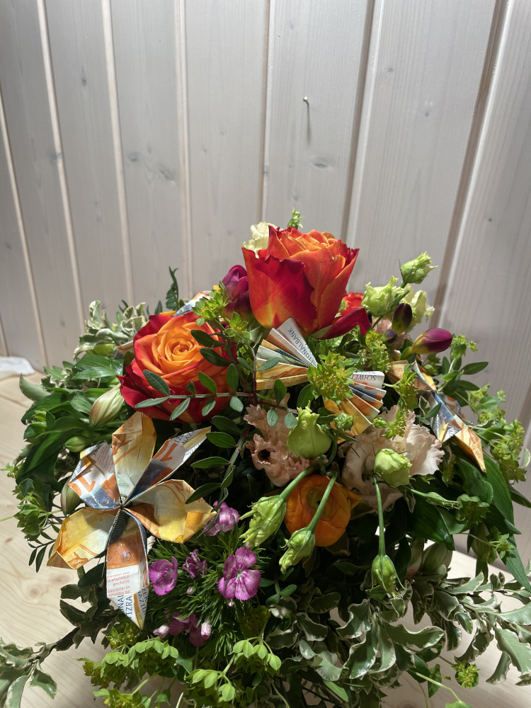 Oranger Bluemstrauss mit Geld für ein Geschenk