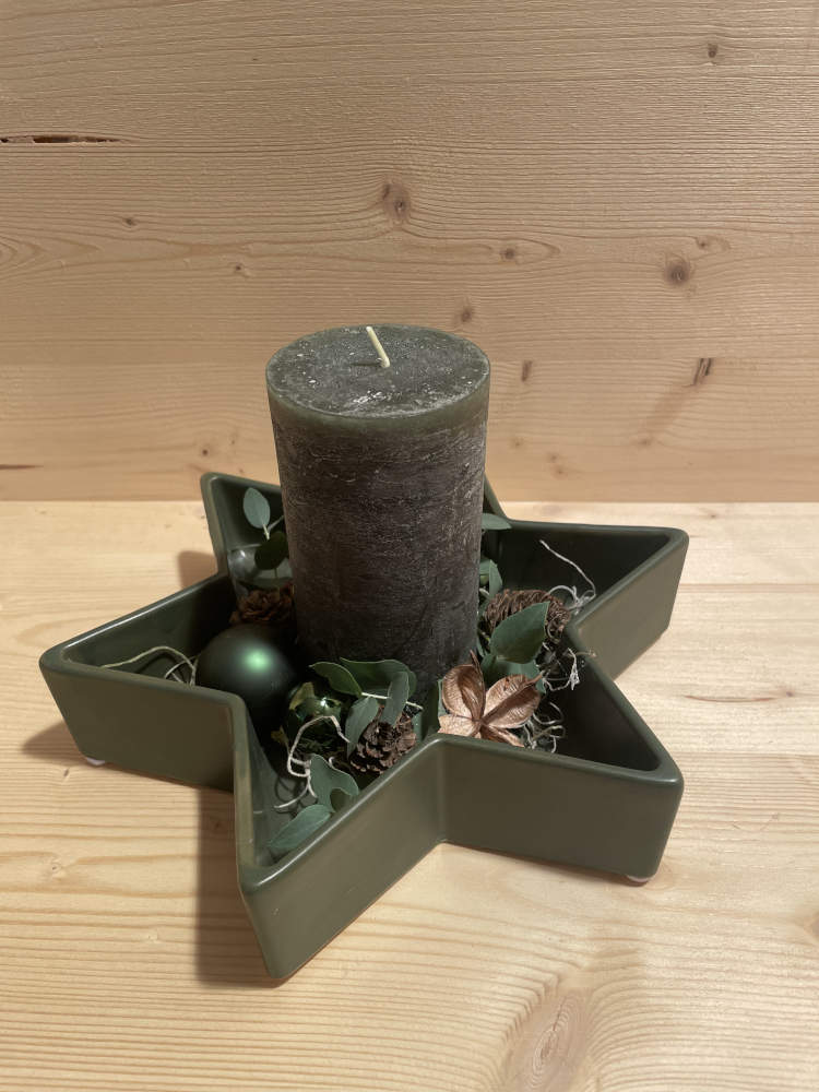 Kerzenarrangement in dunkel-grün in einer Sternschale weihnachtlich ausdekoriert