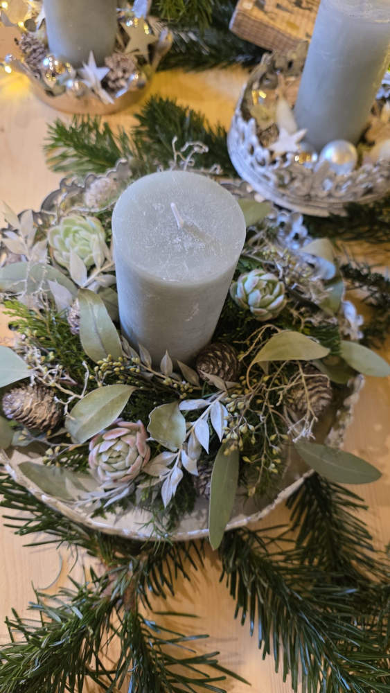 Kranz gesteckt in den grüntönen mit einer Kerze in der Mitte