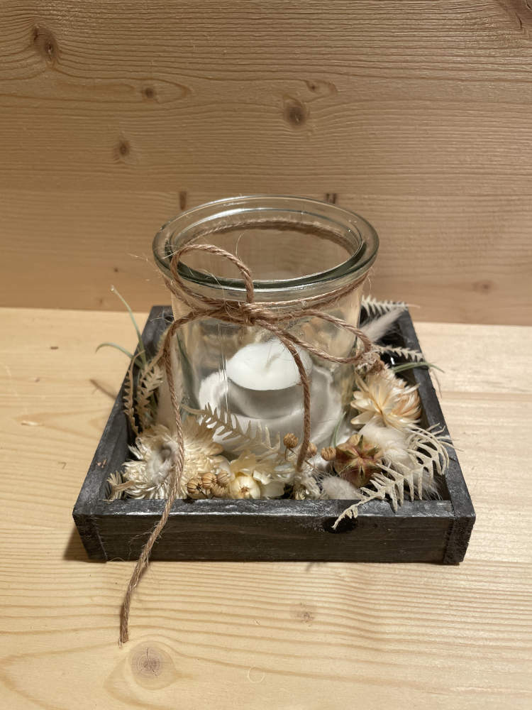 Glas auf einem Hozltablett schöne ausdekoriert. mit einer Kerze im Glas