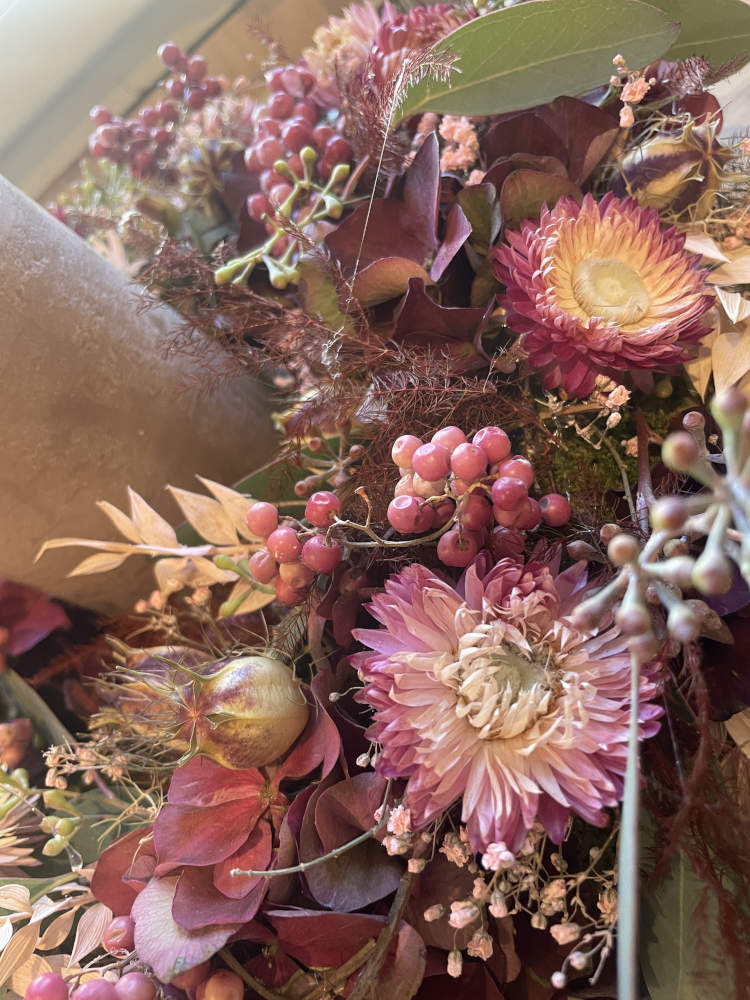 Herbstkranz in rosa mit einer Kerze in der Mitte